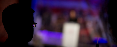 A man watching a speaker from the Remember America Speaker Series